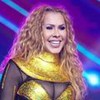 Joelma em foto publicada no Instagram; a cantora está no palco, sorrindo durante um show e veste uma fantasia dourada