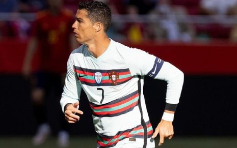 Cristiano Ronaldo com a camisa branca com detalhes em vermelho e verde de Portugal correndo em campo para o lado esquerdo em partida na Eurocopa