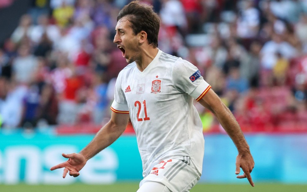 Mikel Oyarzabal com uniforme branco da Espanha com a boca aberta correndo para a esquerda em comemoração de gol em partida
