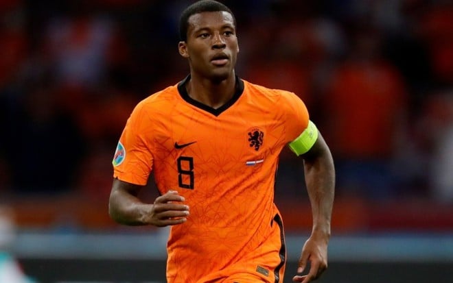 Wijnaldum com a camisa laranja da Holanda e braçadeira de capitão amarela olhando para a direita em partida na Eurocopa