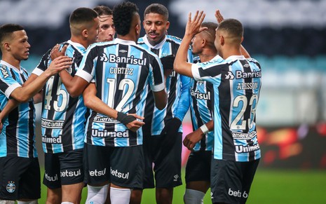 Foto dos jogadores do Grêmio reunidos em campo