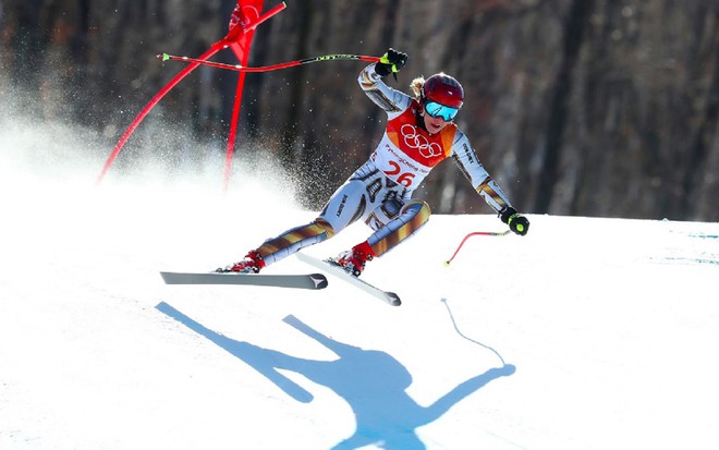 Uma disputa de ski na neve nos Jogos Olímpicos de Inverno. Ela usa uma roupa branca e vermelha e representa a Suíça.