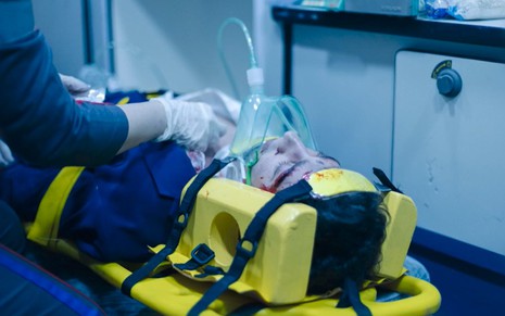 Em cena de Terra e Paixão, Johnny Massaro está recebendo atendimento médico em uma ambulância