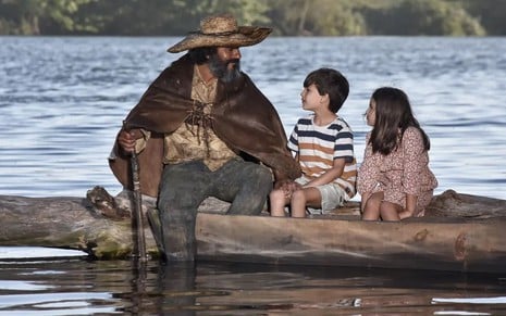 O ator Marcos Palmeira está caracterizado como seu personagem em Pantanal, com Theo e Lia Luperi