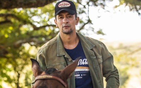 O ator Irandhir Santos montado a cavalo, caraterizado como seu personagem, José Lucas, em Pantanal