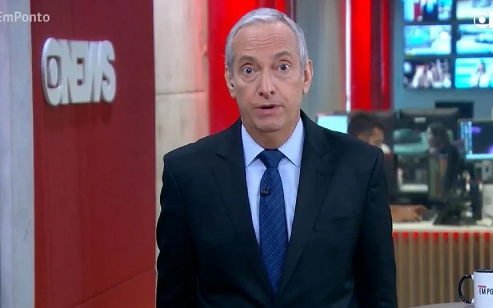 José Roberto Burnier com uma gravata azul, camisa azul e terno preto no cenário da GloboNews em São Paulo