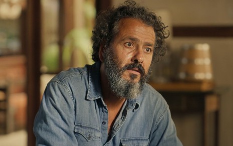 O ator Marcos Palmeira como José Leôncio em Pantanal; ele está sentado, olhando para frente com cara de espantado
