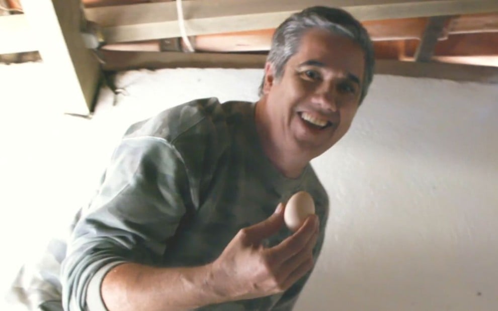 Imagem de Rogério Flausino segurando ovo de galinha do seu galinheiro