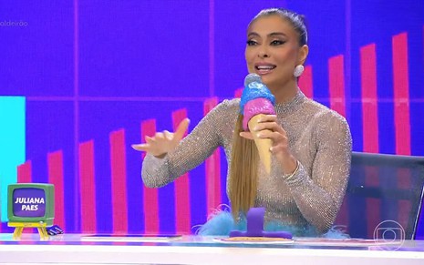 Juliana Paes com uma blusa cinza e microfone com jeito de sorvete no Caldeirão com Mion