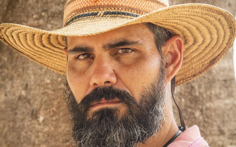 O ator Juliano Cazarré com chapéu e barba, caracterizado como o peão Alcides, da novela Pantanal, da Globo