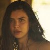 A atriz Alanis Guillen como Juma em Pantanal; ela está olhando fixamente com cara de mistério