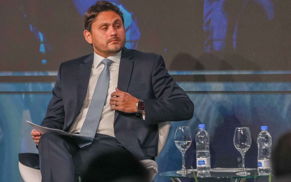 O ministro Juscelino Filho (Comunicações), durante painel na SET Expo, evento das redes de TV; ele usa terno escuro, camisa clara e gravata cinza