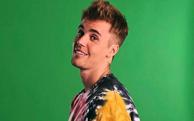 Foto de Justin Bieber sorridente e vestindo camiseta colorida