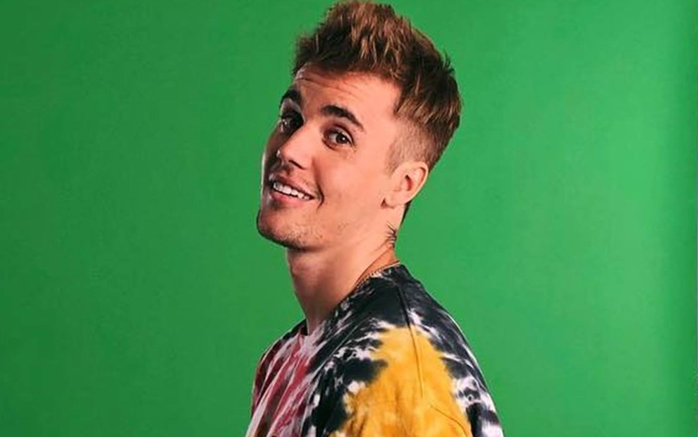 Foto de Justin Bieber sorridente e vestindo camiseta colorida