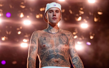 Imagem de Justin Bieber de boné branco e sem camisa durante show