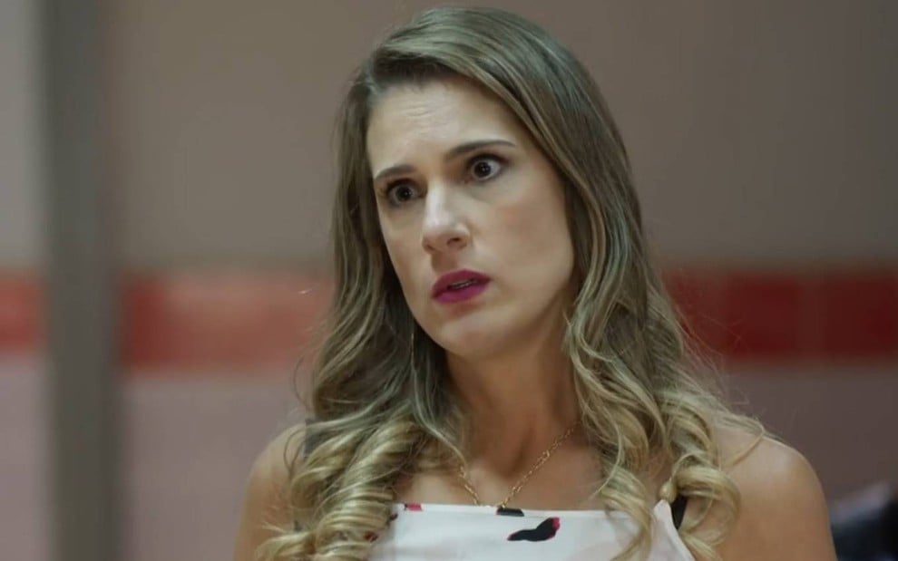 Atriz Karina Dohme olha para frente com cara de séria em cena de Quanto Mais Vida, Melhor