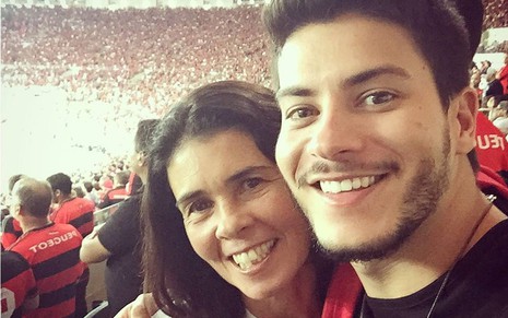 Kátia e Arthur Aguiar sorriem em estádio de futebol