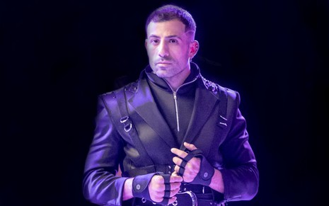 Kaysar Dadour está vestindo uma jaqueta, figurino do personagem dele em Cara e Coragem