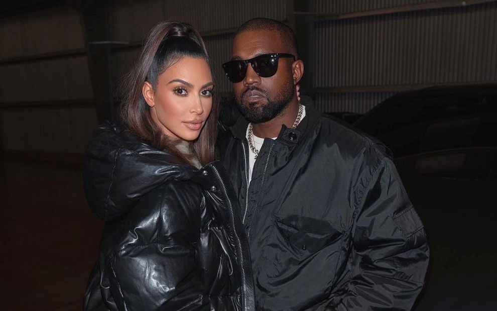 Kim Kardashian e Kanye West posando juntos em frente a um carro