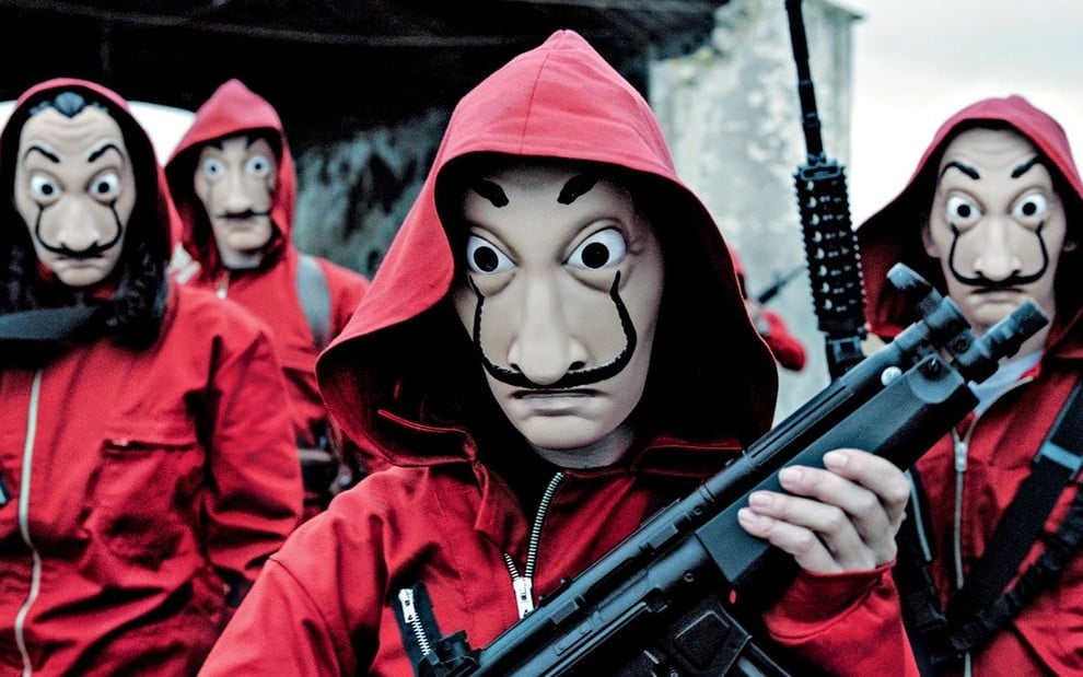 Imagem dos personagens de La Casa de Papel mascarados e armados em cena da série Netflix