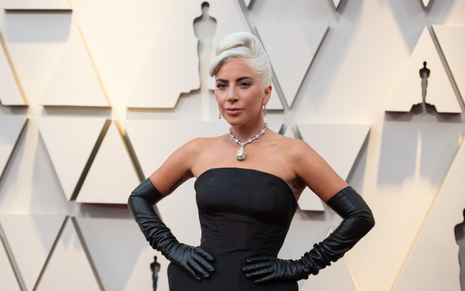 Lady Gaga usa vestido preto tomara que cai com um colar de pedras preciosas em evento do Oscar