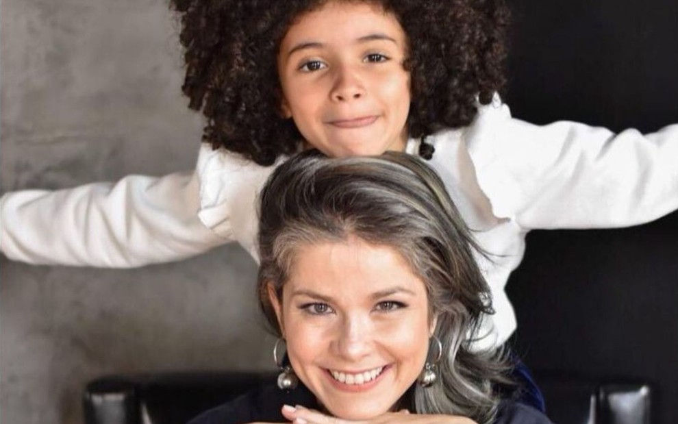 A atriz Samara Felippo sorri com a filha caçula, Lara, em cima dela, em foto publicada no Instagram