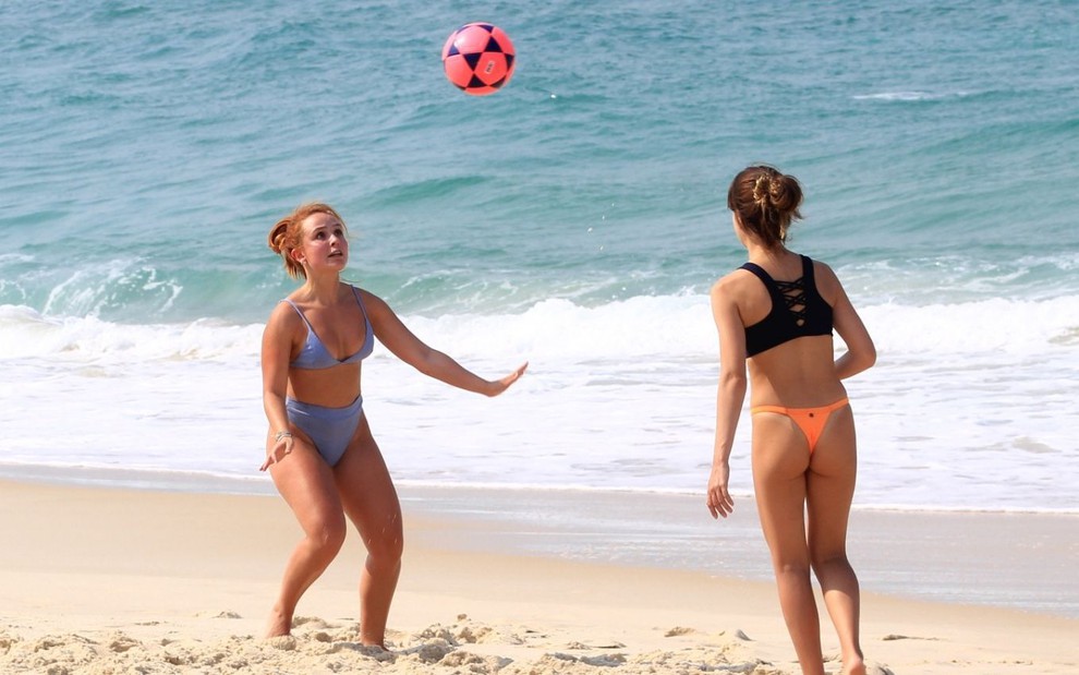 Larissa Manoela joga bola com amiga em praia do Rio de Janeiro; as duas estão de biquíni e próximas ao mar