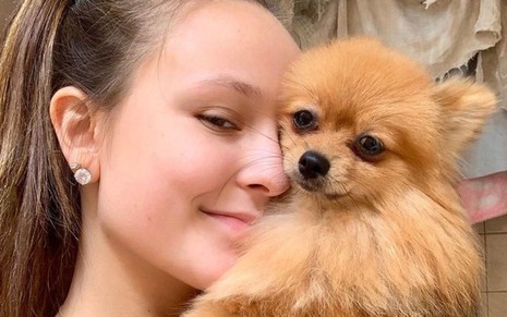 A atriz Larissa Manoela segura uma cachorra da raça lulu da Pomerânia