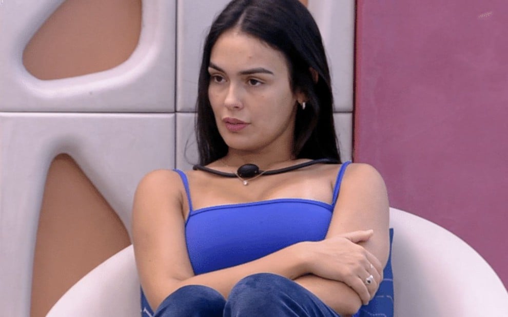 Larissa Santos sentada no sofá da área externa do BBB 23