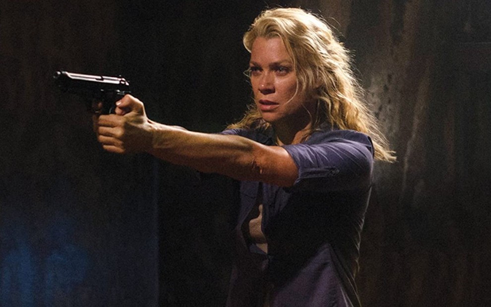 Laurie Holden aponta uma arma em cena da série The Walking Dead