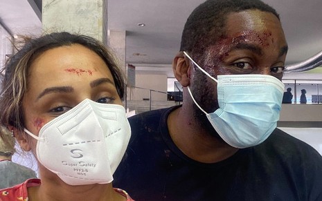 Lázaro Ramos e Thaíssa Carvalho estão maquiados como se estivessem feriados e usando máscara