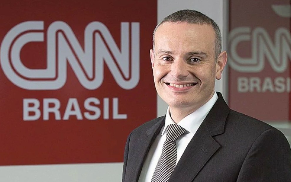 O jornalista Leandro Cipoloni com a logo da CNN Brasil no fundo