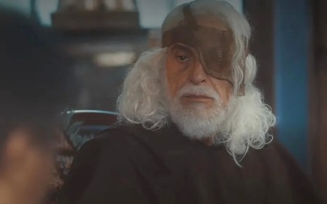 Paulo Gorgulho caracterizado como Leonel; ele está com a barba longa e os cabelos despenteados em cena da novela. O semblante exprime confusão.