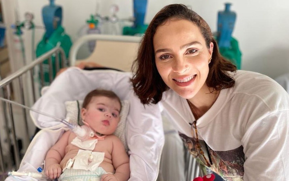 Maria Guilhermina em um leito de hospital ao lado da mãe, Letícia Cazarré