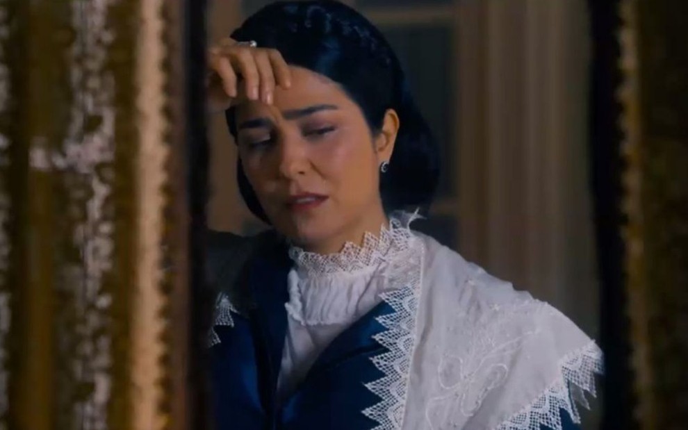 Leticia Sabatella apoia o braço na parede e está com expressão de choro em cena como Teresa Cristina em Nos Tempos do Imperador
