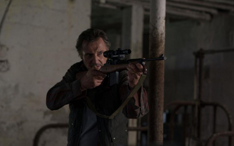 Liam Neeson aponta uma arma