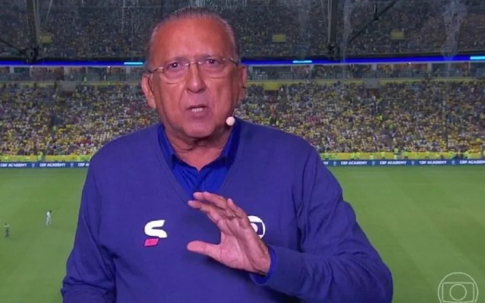 Galvão Bueno com uma blusa azul e falando durante uma transmissão da Seleção Brasileira no Maracanã