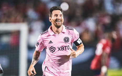 Lionel Messi sorridente em campo com o uniforme rosa do Inter Miami nos Estados Unidos