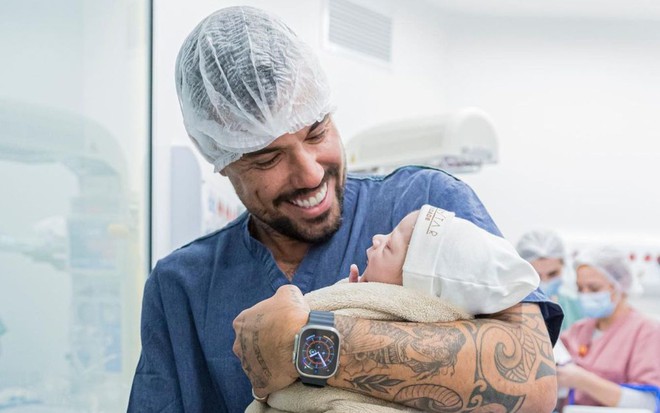 Lipe Ribeiro segura Dom no colo na sala de parto