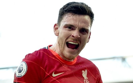 Robertson, do Liverpool, grita ao comemorar gol e veste uniforme vermelho com detalhes branco e laranja