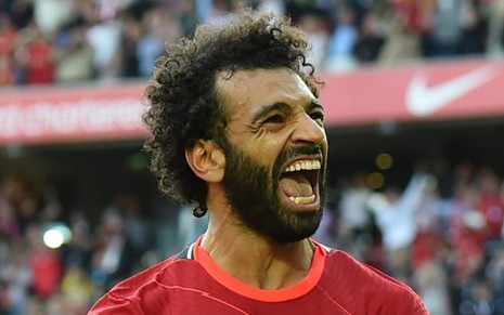 Mo Salah, atacante do Liverpool, comemora gol na Premier League em Anfield, na Inglaterra. Ele usa a camisa vermelha do clube tradicional inglês