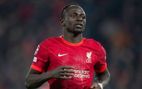 Sadio Mané, do Liverpool, corre em campo e veste uniforme vermelho com detalhes brancos e laranja