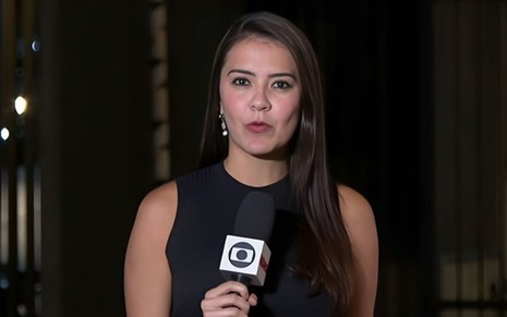 A jornalista Lívia Torres com o microfone com o logo da Globo na mão