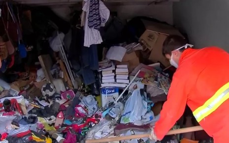 Imagem de gari limpando residência de acumulador de Agudos, no interior de São Paulo