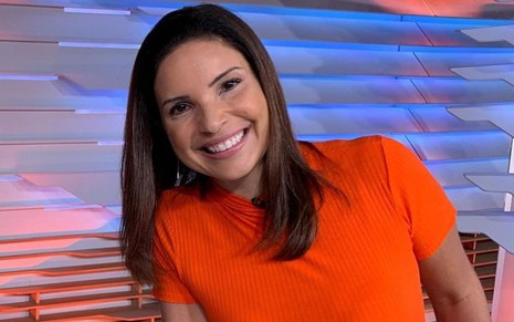 Lizandra Trindade na bancada do Bom Dia Brasil, com uma camisa laranja