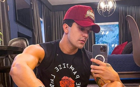 De boné, Luan Santana exibe braços musculosos em selfie de regata preta na frente do espelho