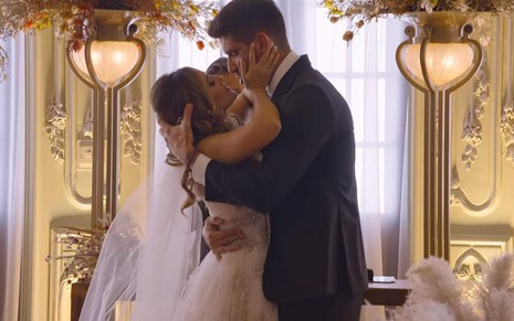 Luana e Lissio se beijam durante cerimônia de casamento, vestidos de noivos, no reality Casamento às Cegas Brasil