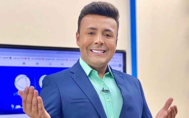 Lucas Ferraz está sorrindo e com as mãos abertas