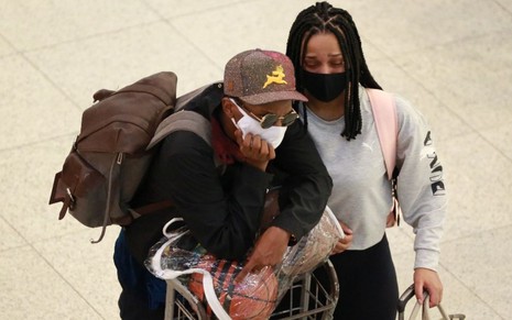 Lucas Penteado e a ex-noiva, Julia Franhani, no aeroporto, com malas e mochilas, lado a lado