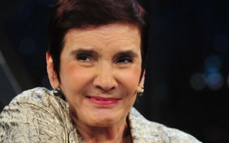 Lucia Hippolito (1950-2023) em participação no Programa do Jô, com leve sorriso, testa franzida